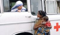 Mother Teresa talking with a poor woman and her child from a Red Cross minibus in Calcutta, India. Photo: AFP