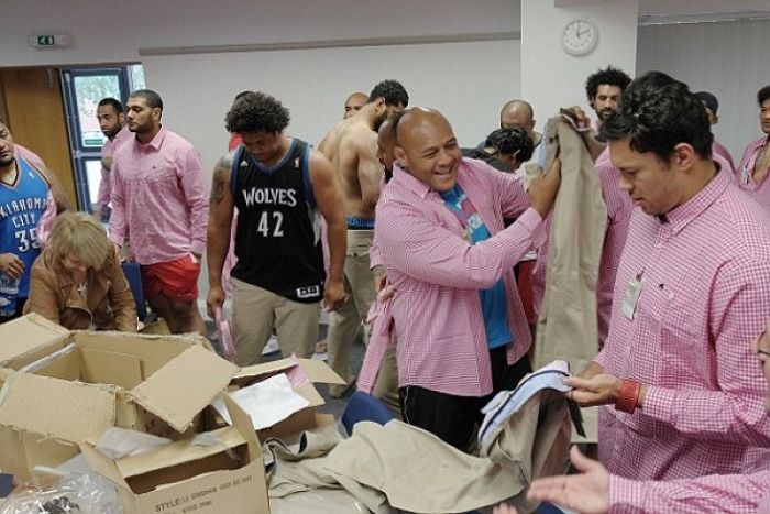 The Tonga players look delighted as they try on their new clothes ahead of the 2015 Rugby World Cup (Photo by MailOnline)