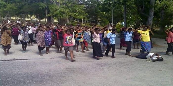 Students show bodily sign of respect to a student who was killed and students who were shot